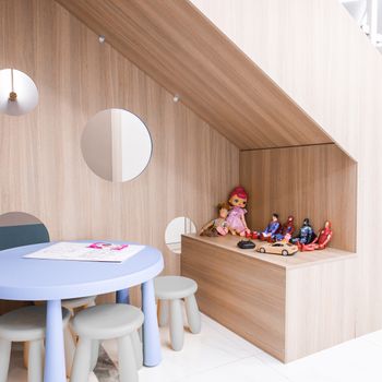 A stylish playroom with round table, stools, and toys, ideal for modern preschools.（イメージ）