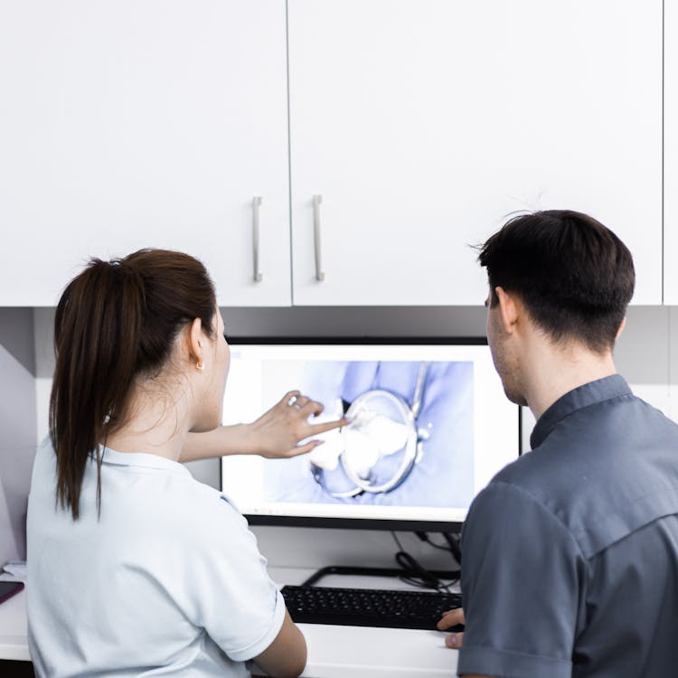 Dentists Looking At Tooth On Screen