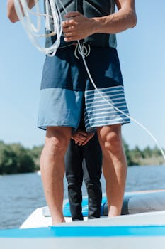 Father and child on a boat preparing for water sports on a sunny day.