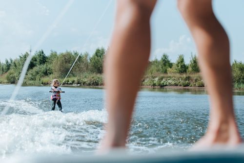 Free Young girl wakeboarding on a sunny summer day, showcasing outdoor fun and adventure. Stock Photo