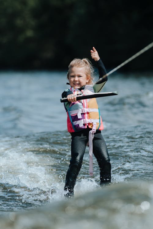 A Young Girl Wakeboarding and Looking at Camera 