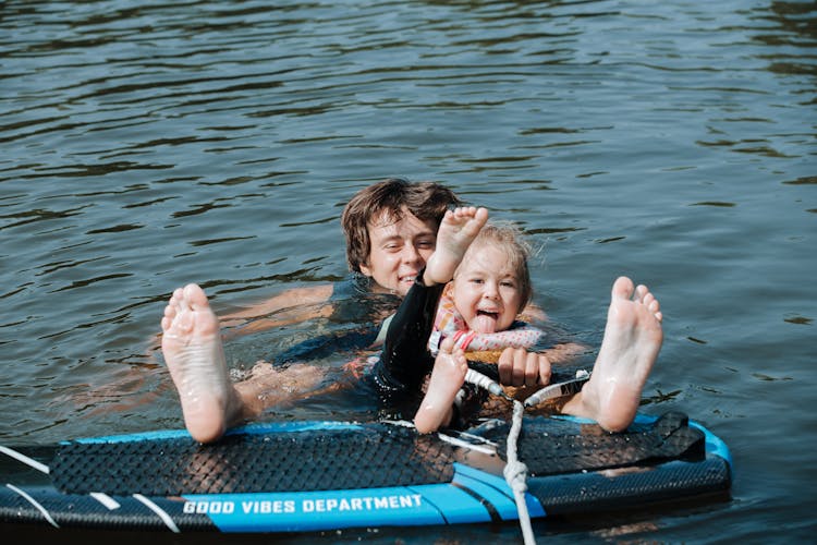 Father InWater With Daughter With Wakesurf Board