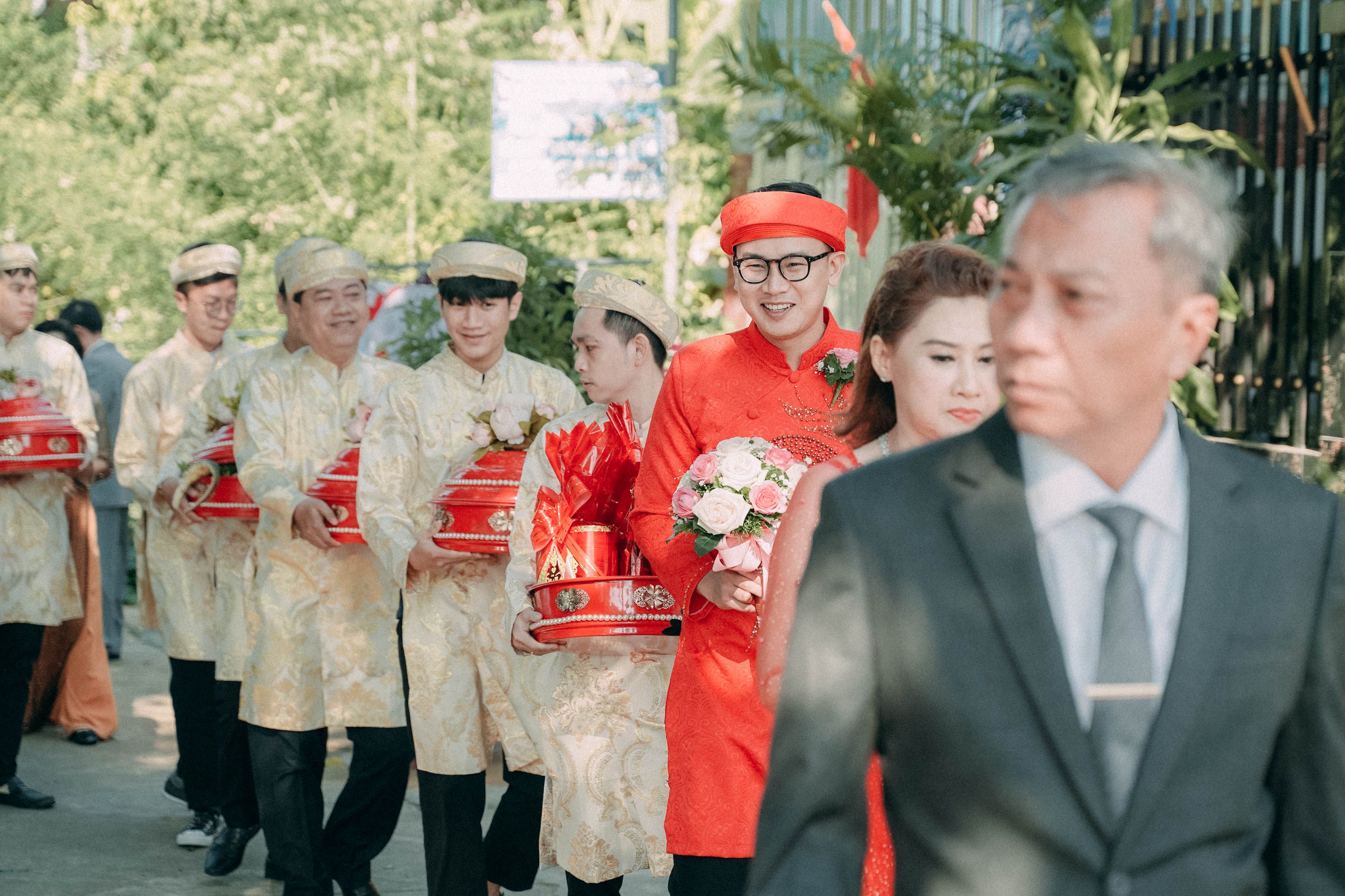 A vibrant traditional wedding procession featuring gifts and ceremonial dress outdoors.