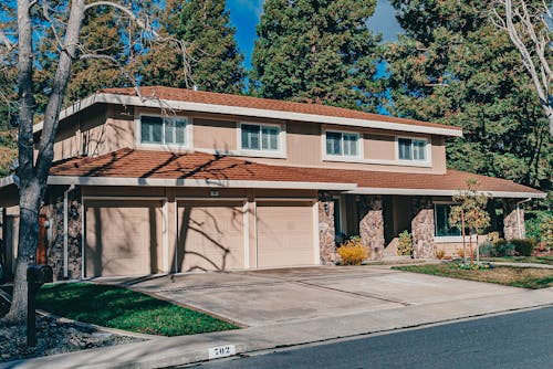 Photograph of a Brown House Near Green Trees