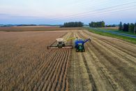 Aerial shot of a harvester and tractor during harvest in rural Minnesota.