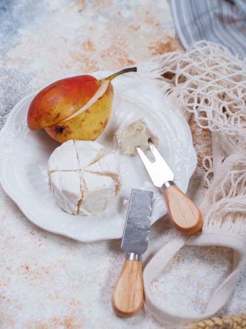 Free Appetizing setup of camembert cheese and pear on a plate, perfect for culinary presentations. Stock Photo