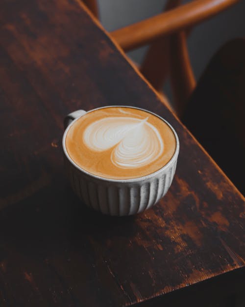 Close-Up Shot of a Cup of Cappuccino on a Wooden Table