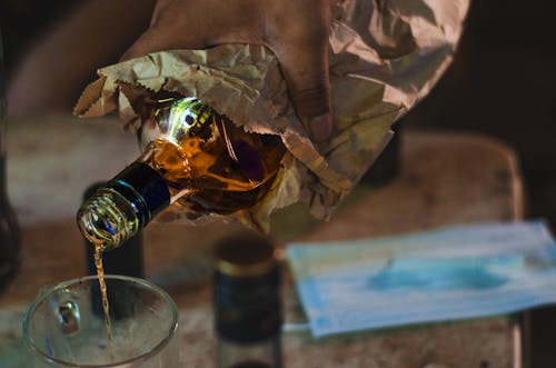 Close-Up Shot of a Person Pouring a Liquor on a Glass