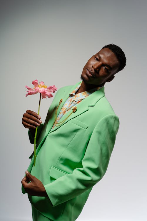 Vertical Shot of a Man in a Suit Holding a Flower