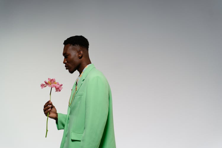 A Man In Green Suit Holding A Flower