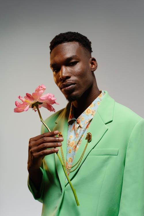 Free A Man in Green Suit Holding a Flower Stock Photo