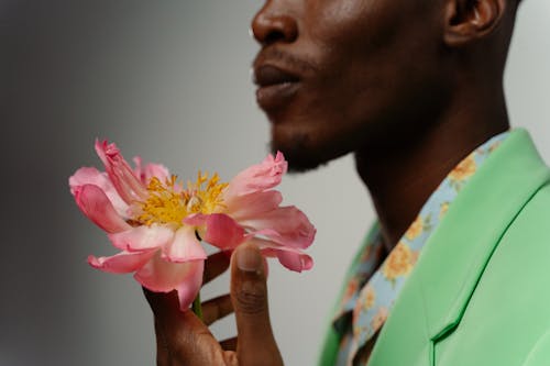Close-Up Shot of a Man Holding a Pink Flower