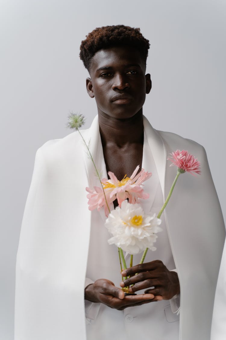 A Man In White Coat Holding Flowers