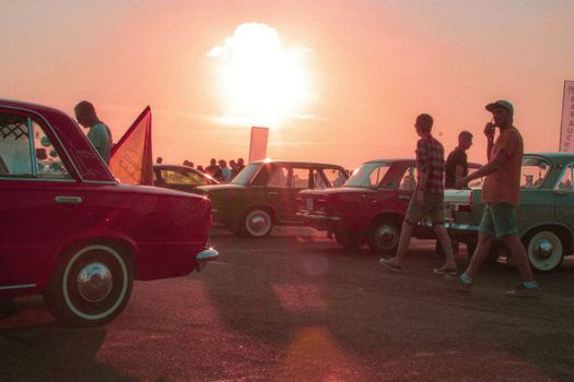 Vintage cars parked outdoors during a vibrant sunset in Krasnodar, Russia.