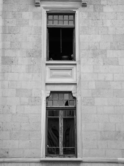 Grayscale Photo of a Concrete Building with Glass Windows