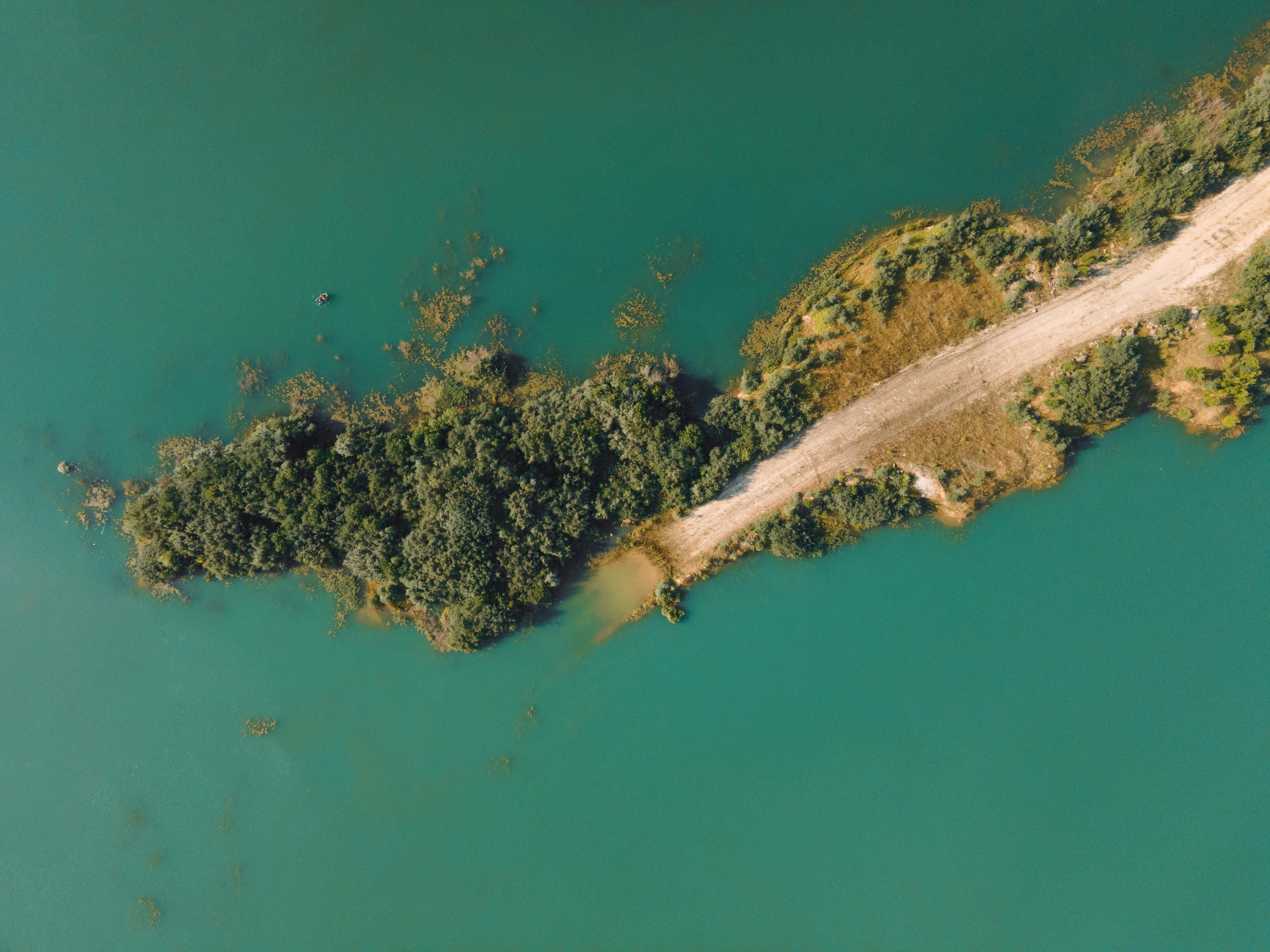 Aerial Photography of Dirt Road Near Body of Water · Free Stock Photo