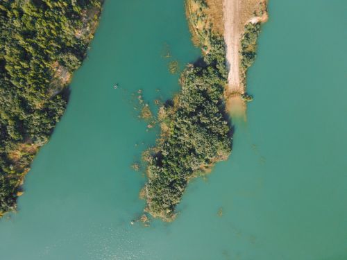 Free Aerial shot of a small lush island surrounded by turquoise waters. Stock Photo