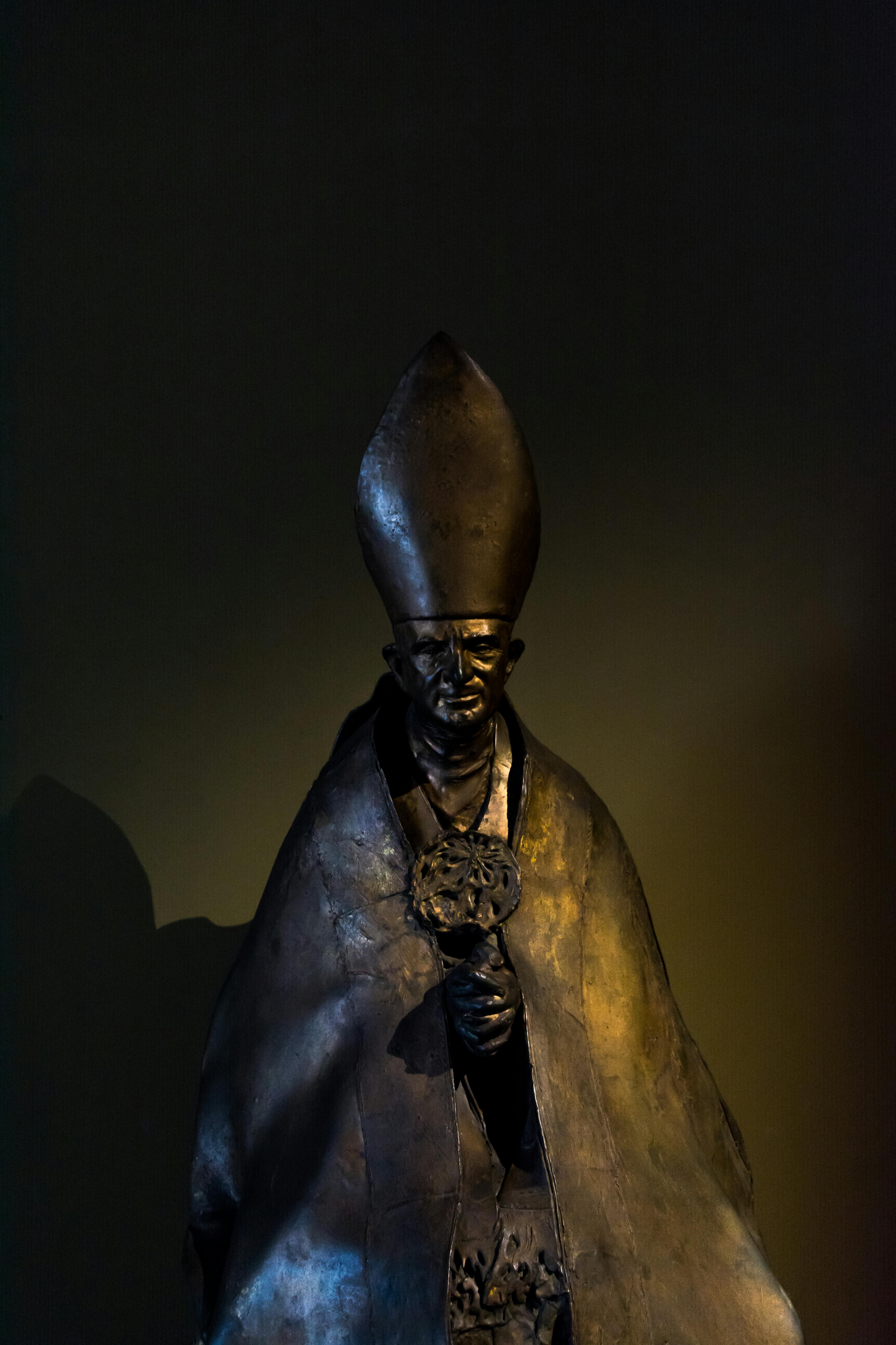 Dramatic bronze sculpture of a religious figure in Rome, beautifully lit against a dark backdrop.