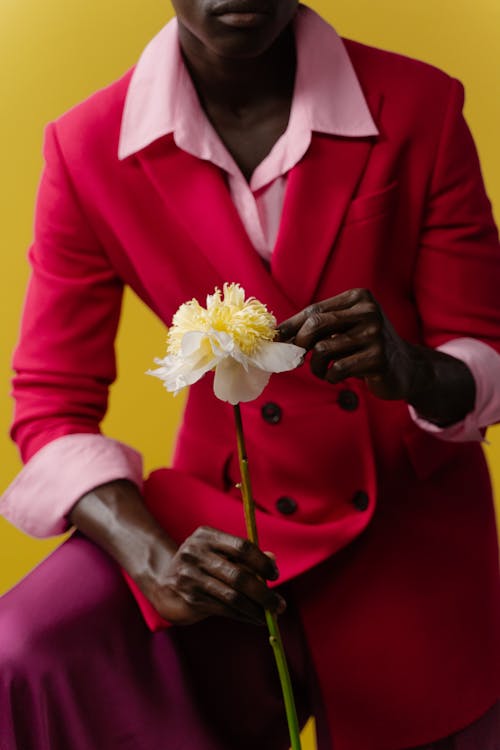 Person in Red Colorful Outfit Holding a Flower