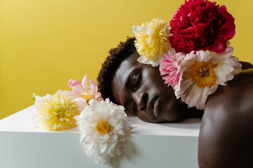 A Man Lying Down Surrounded by Flowers