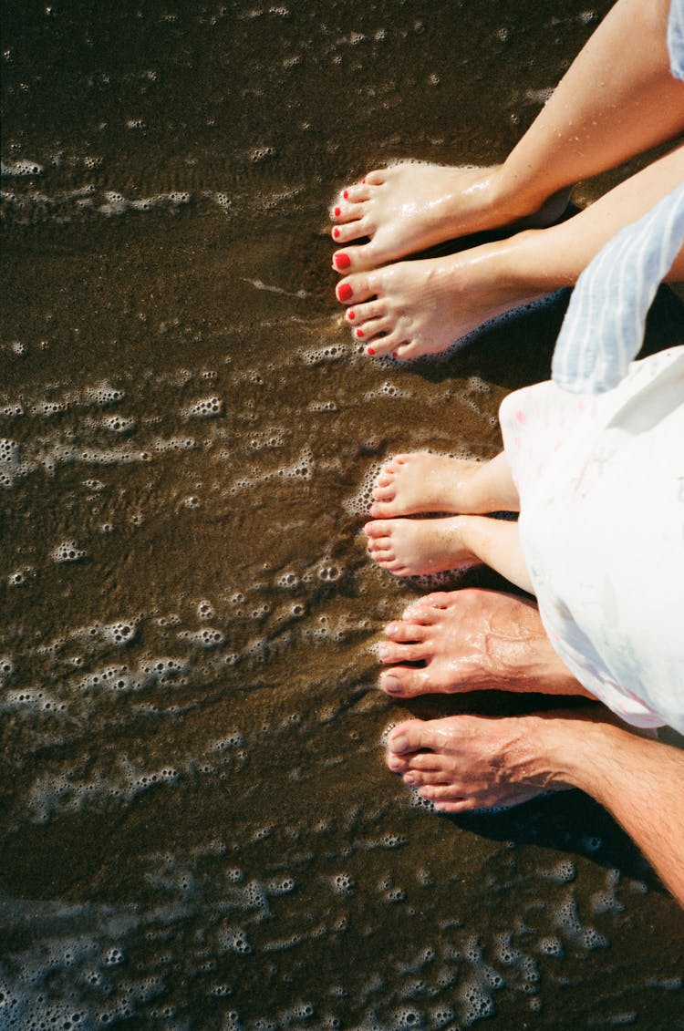 Close Up On Peoples Feet In Water