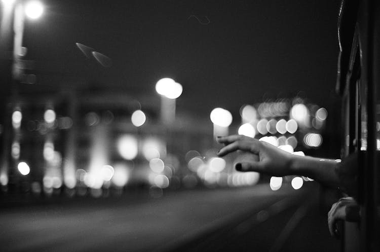 Black And White Picture Of Hand Reaching Out From Train Window