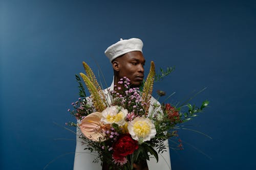 A Man in White Long Sleeves Holding Flowers