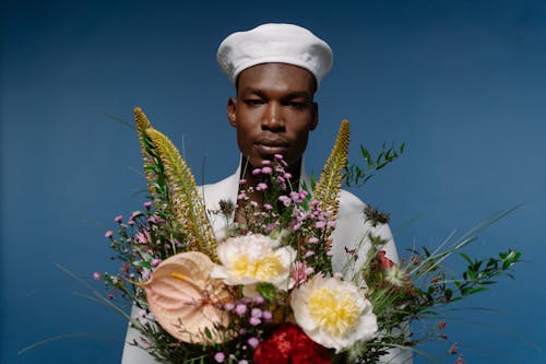 Man in White Hat with Bouquet of Flowers in Hands