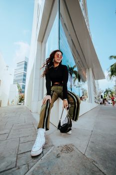 Fashionable woman with long hair in urban setting, reflecting modern city lifestyle.