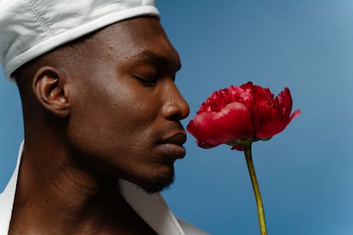 Close up Shot of a Man Posing with a Red Flower