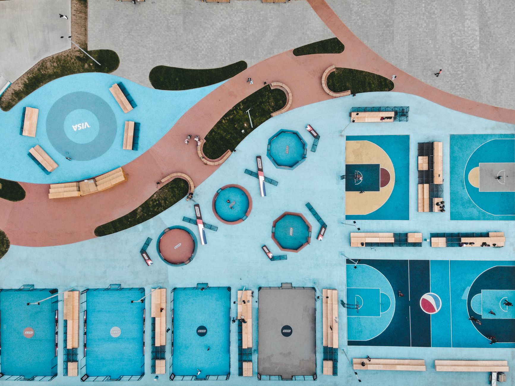 Vibrant sports complex in Kyiv featuring basketball and tennis courts viewed from above.