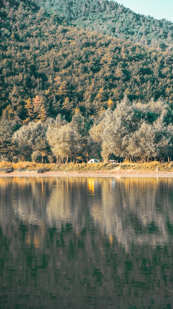 Paisagem de outono serena com reflexo do lago e da floresta em Amasya, Turquia.