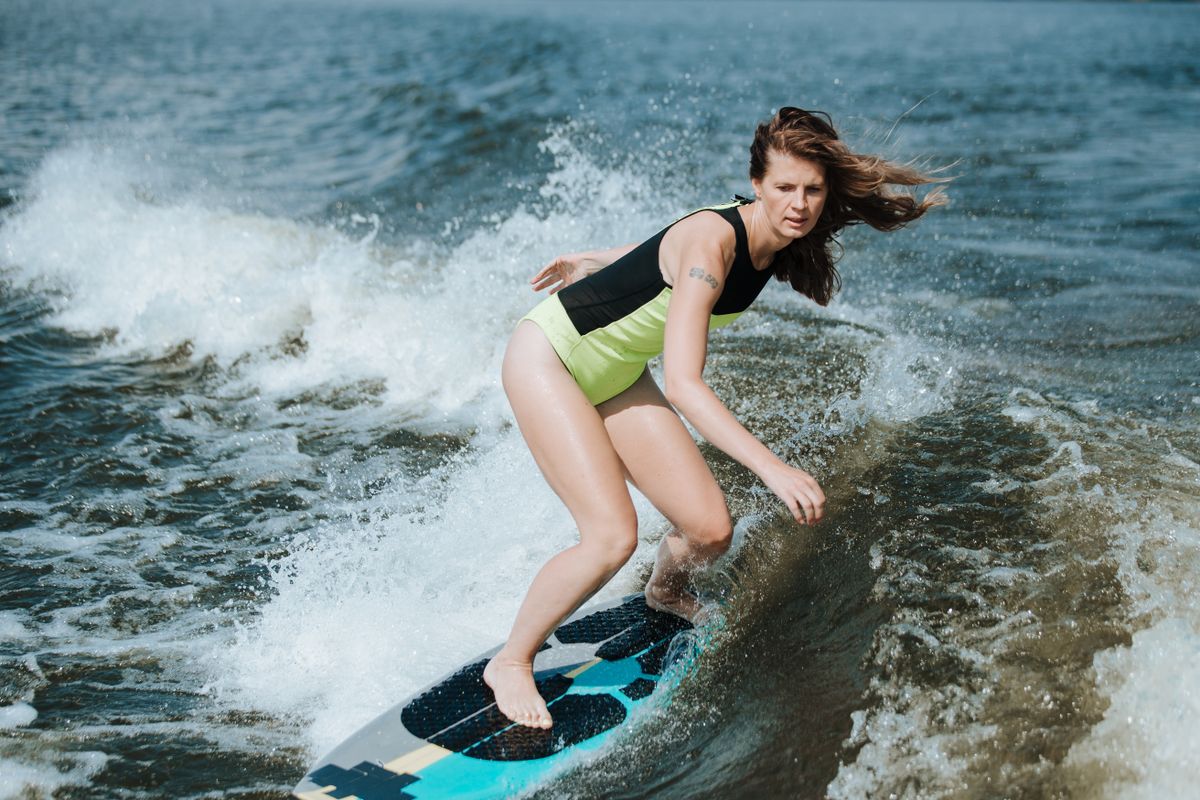 Wakesurfer carving on the wake on a calm lake