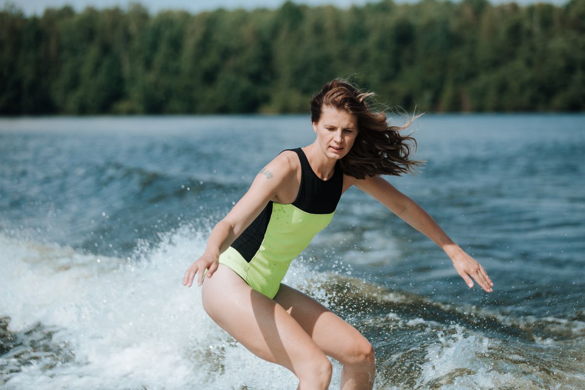 Wakesurfer riding the wake behind a boat on a lake