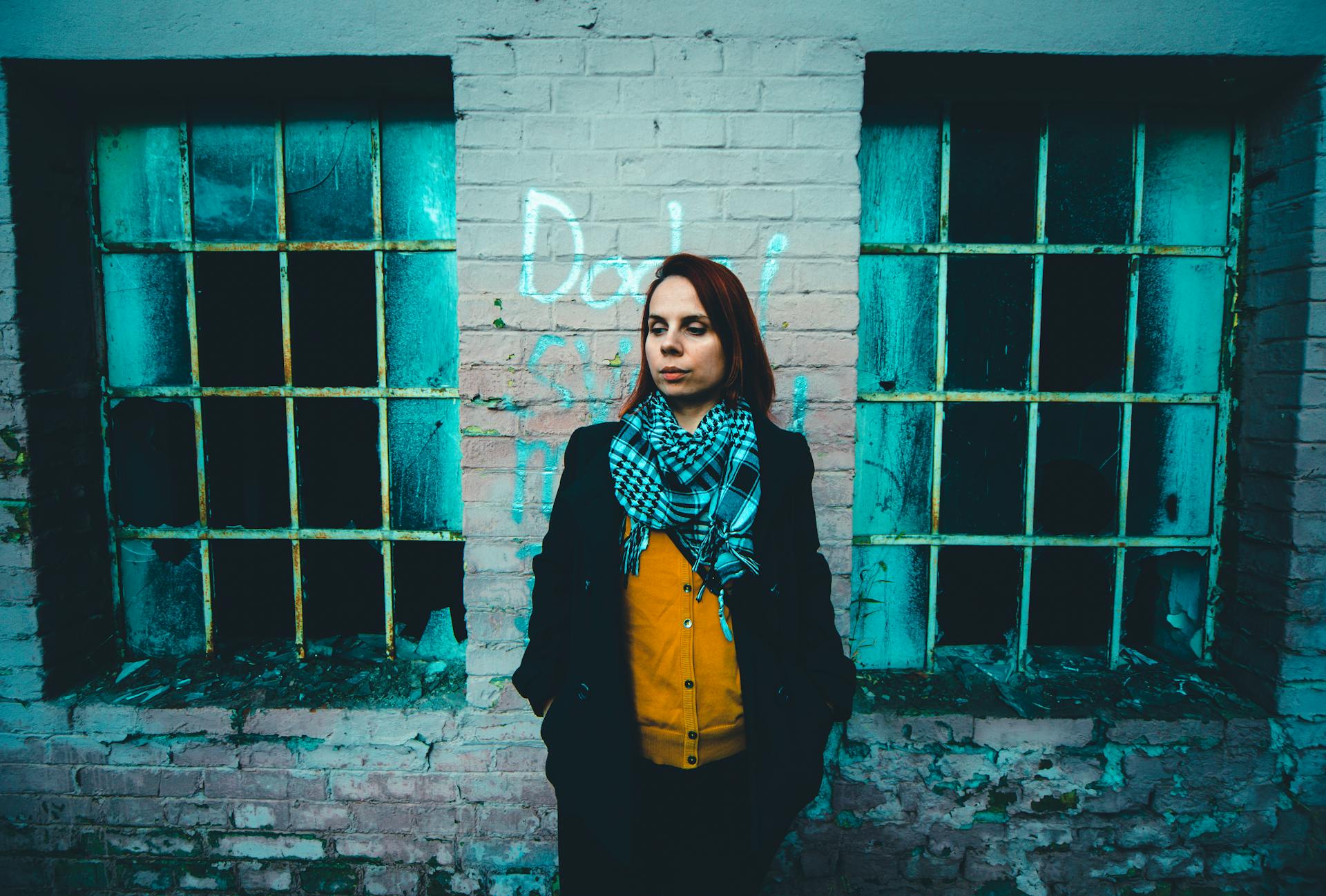 Woman Standing Next to Broken Windows