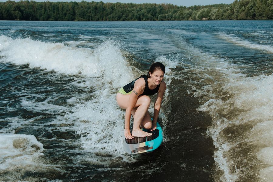 Rider crouching on a wakesurf board