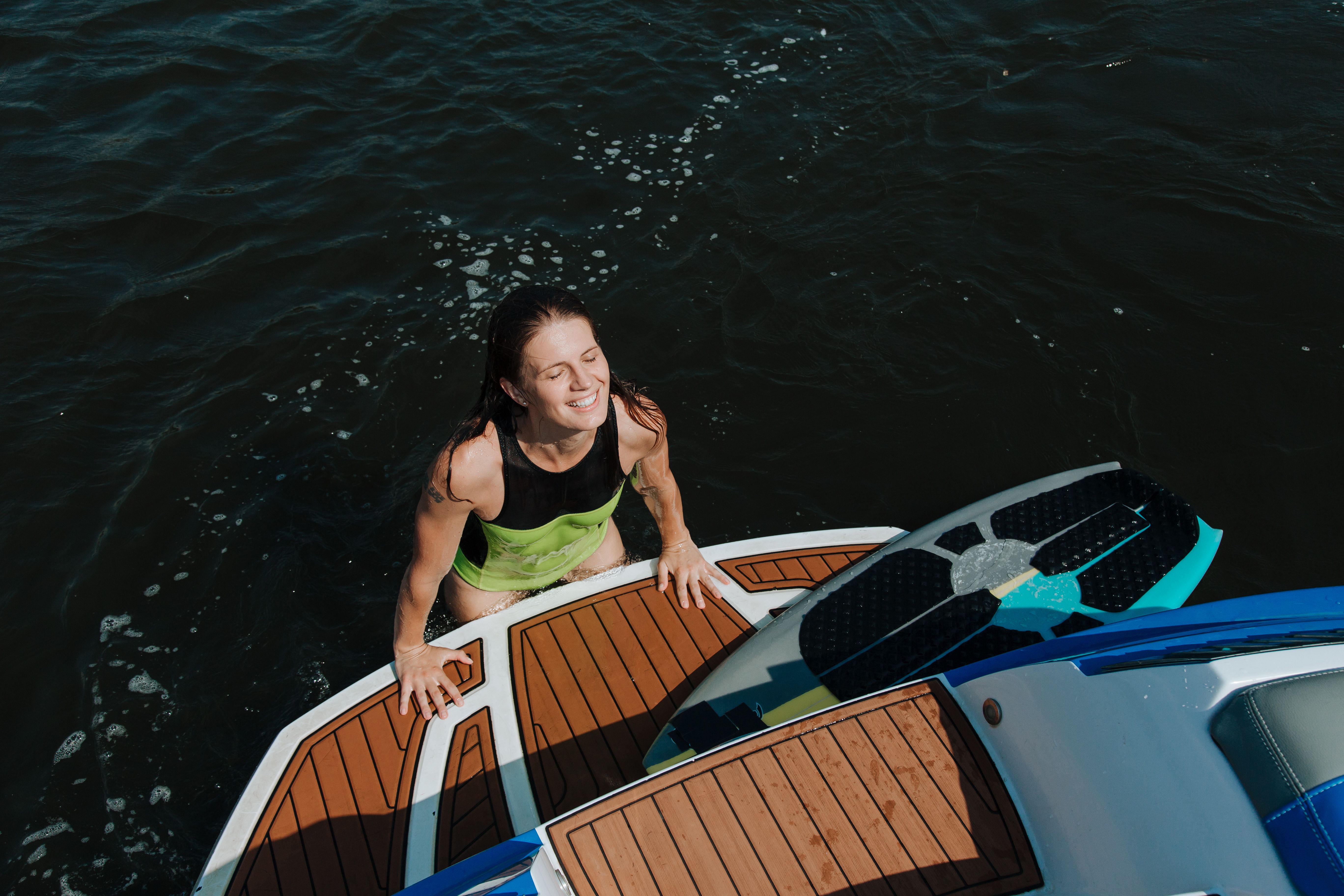 Smiling Woman Climbing on a Motorboat · Free Stock Photo