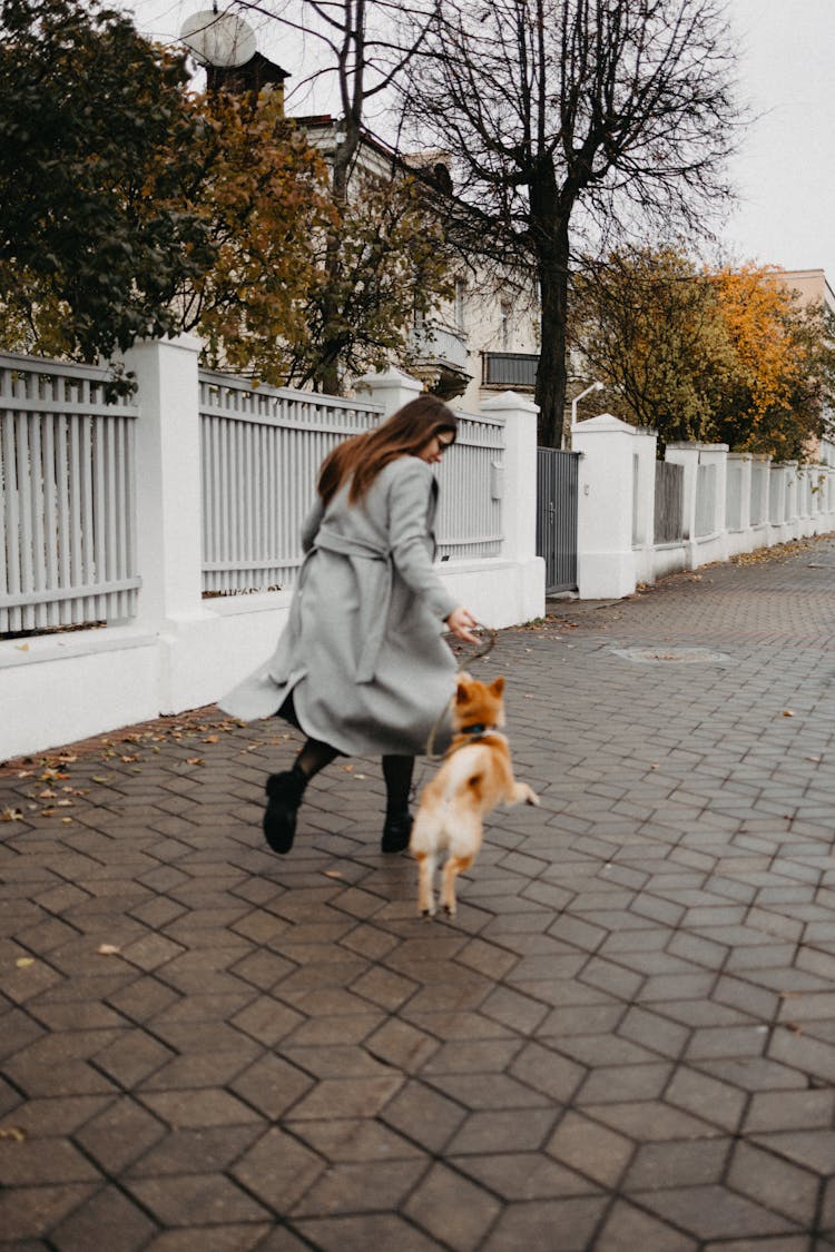 A Woman Running With Her Dog 