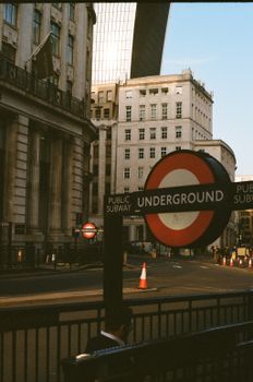Iconic London street scene featuring a classic Underground sign and urban architecture.