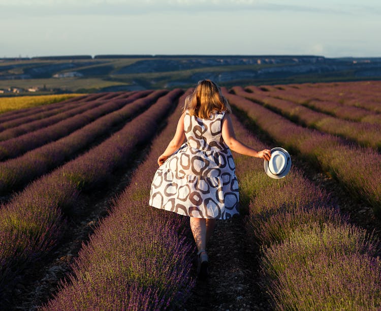 Back View Of Woman Running Through A Lavender Field 