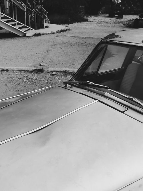 Free Detailed monochrome photo showcasing a vintage car with a damaged hood in an outdoor setting. Stock Photo