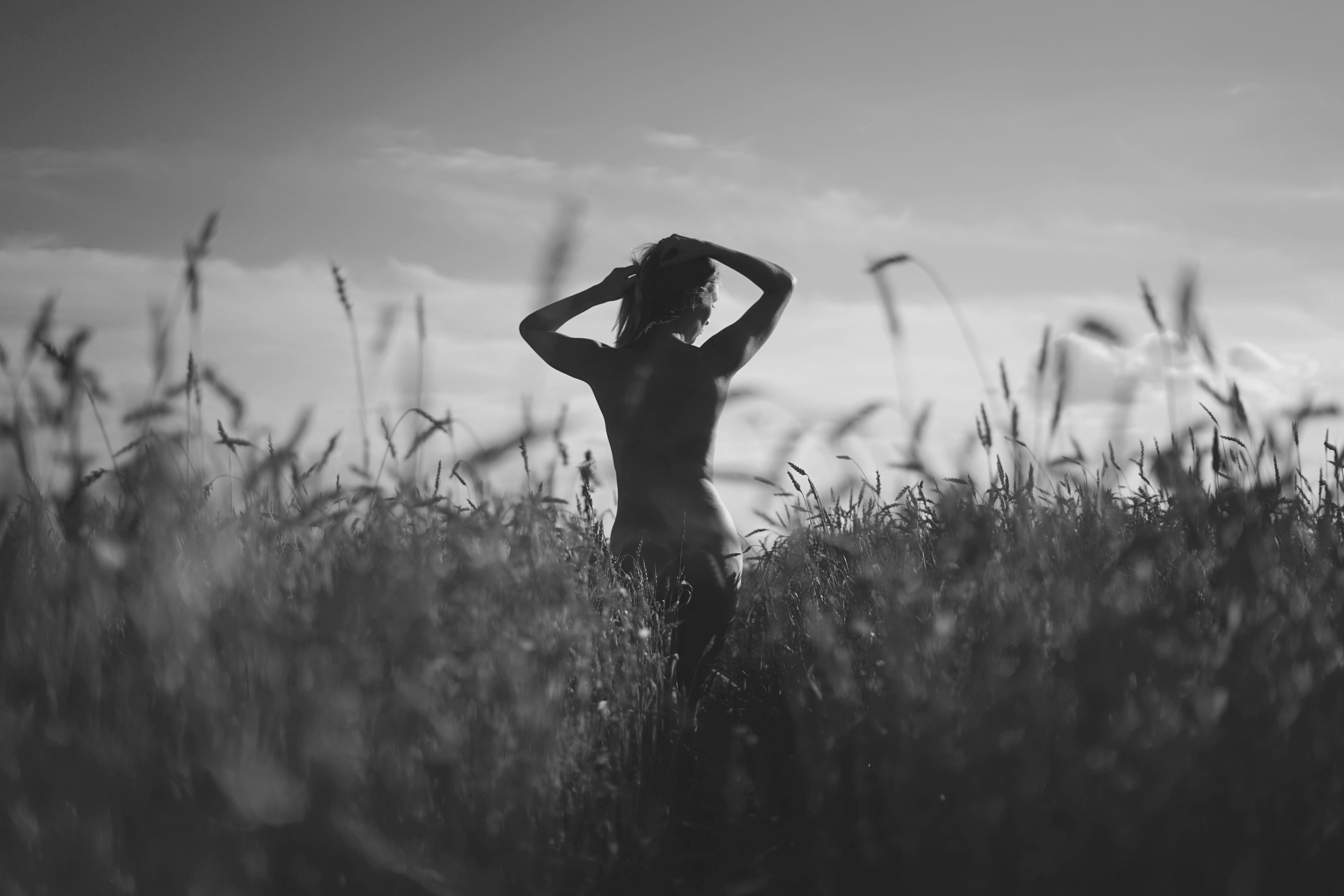 Grayscale Photo of Woman Holding Bouquet of Flowers Standing on Grass ...