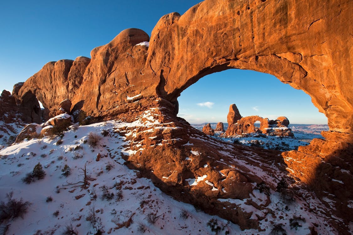 Arch Rock Formation Near Blue Body of Water