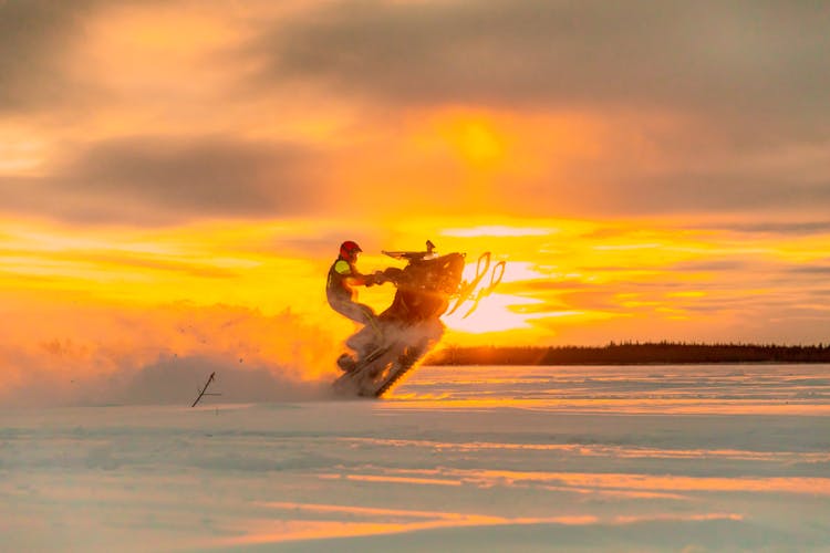 Man Performing Stunt On Snowmobile