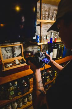 Capturing a photo of liquor shelves in a dimly lit room for a unique indoor perspective.
