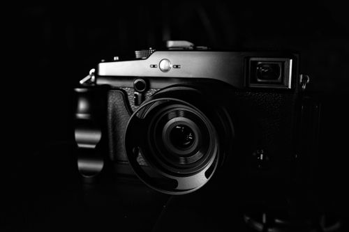 Free Monochrome close-up of a vintage-style mirrorless camera, showcasing its lens and intricate details. Stock Photo