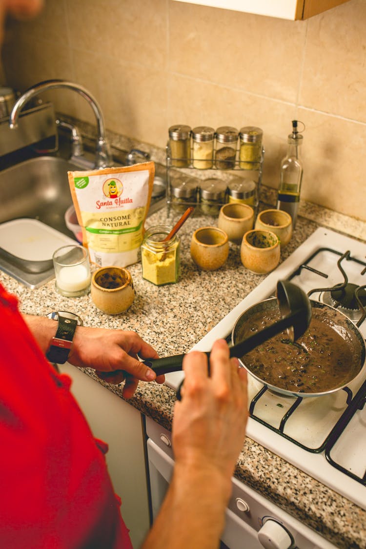 A Person Cooking Soup With A Pan