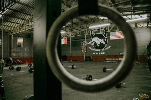 View of an empty gym with barbells and flags, ready for crossfit or weightlifting.