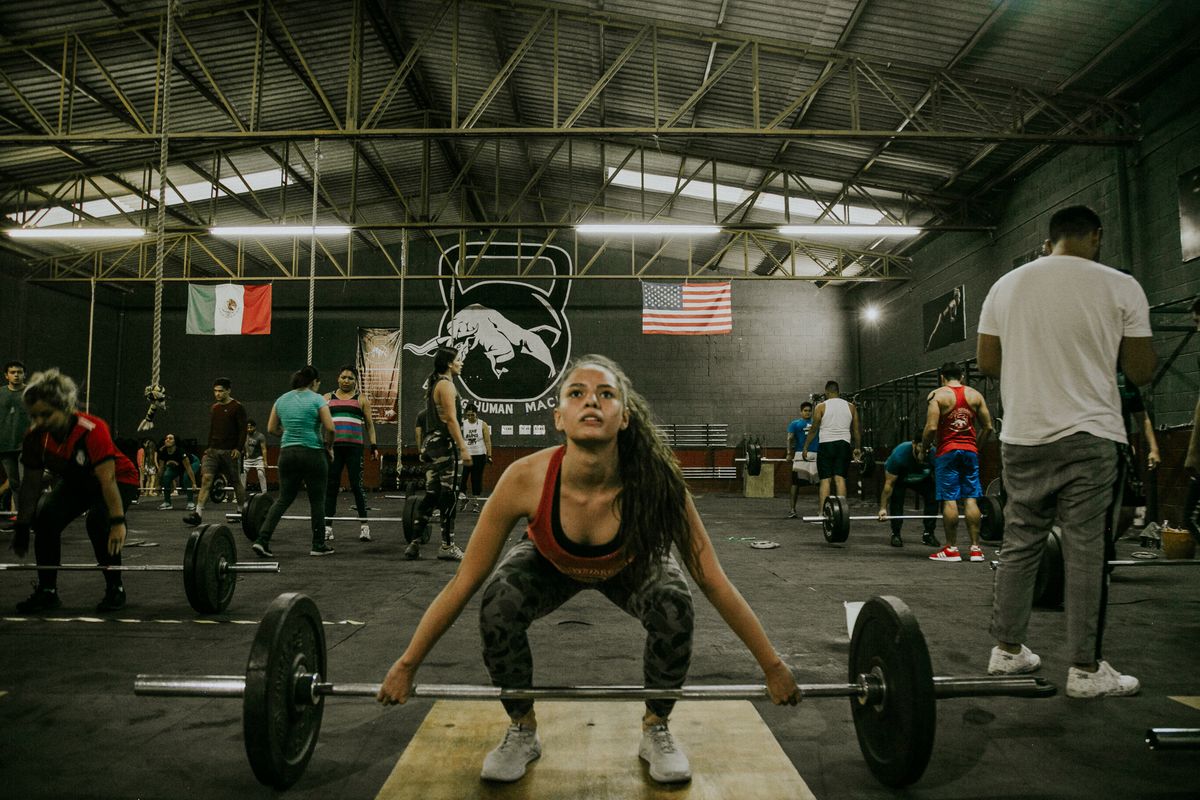 A group of people strength training with weights in a gym