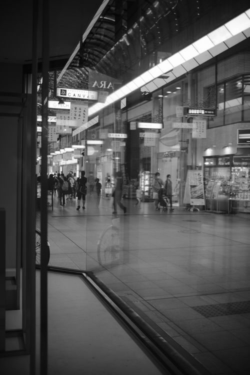 Free Monochrome view of indoor shopping area with people and stores. Stock Photo